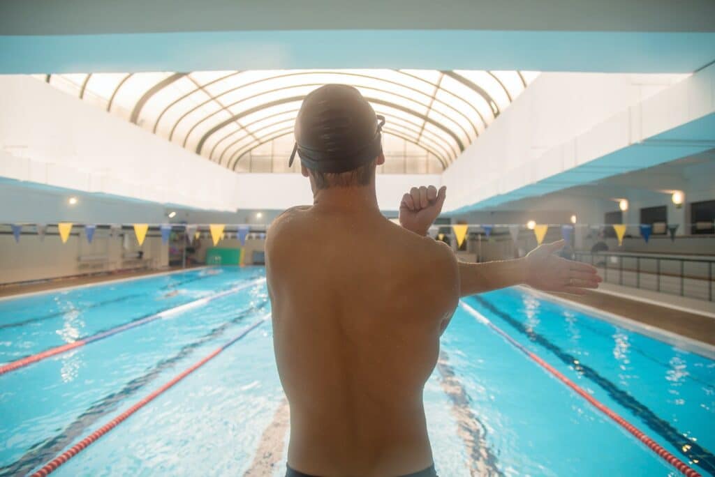 Swimmer stretching shoulder at pool
